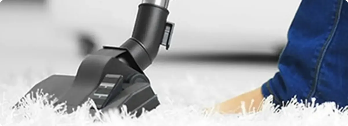 Close-up of a professional vacuuming a white carpet in Gilbert.